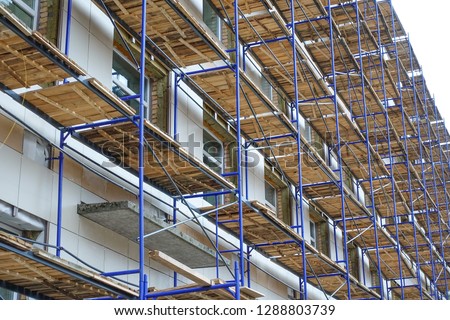 Scaffolding around a high-rise building. Repair work. Renovation of the building Royalty-Free Stock Photo #1288803739