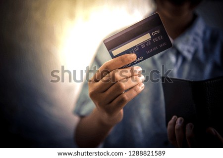 Hands holding credit card from wallet.