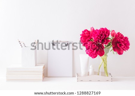 Mockup with a clipboard and red peonies in a vase on a light background