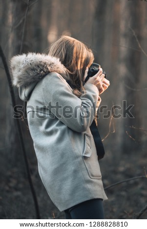Girl taking photo in the forest