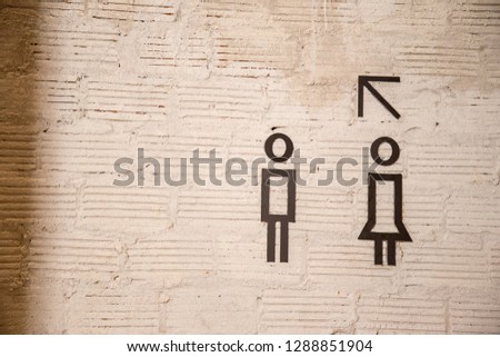 Toilet sign on surface wall with arrow, man and woman symbol on vintage style.