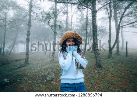 Soft light and misty fog to girl in beautiful nature landscape pine forest at "Phu Ruea National Park" with soft light Morning Mist,dew and cool air in autumn season Loei, thailand.