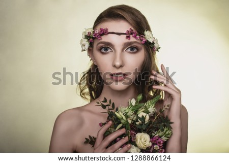 Spring, summer fashion photo shoot at the studio. Beautiful girl with flowers in the background.Tenderness, beauty on the pictures.Beautiful model.Spring composition of natural flowers.Portrait