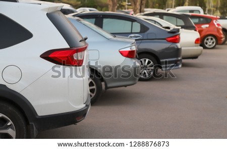 Closeup of rear or back side of white car with  other cars parking in parking area in the evening of sunny day. The mean of simply transportation in modern world. Royalty-Free Stock Photo #1288876873