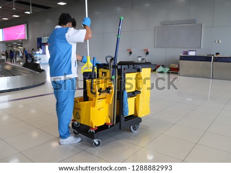 Closeup of woman cleaning worker doing her work with janitorial, cleaning equipment and tools for floor cleaning at the airport. Royalty-Free Stock Photo #1288882993