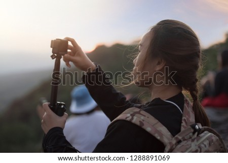 Beautiful Asian Woman Using Action Camera for Take a Photo During Travel Trip on Sunset Time Relax Emotion