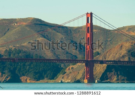 The Golden Gate bridge with moutain background. The blue tone of picture make feeling calm.