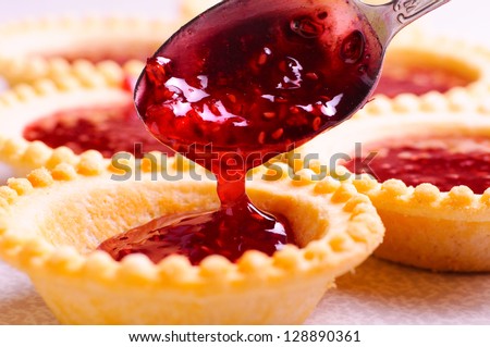set of tasty tartlets with raspberry jam Royalty-Free Stock Photo #128890361