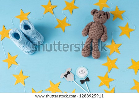 booties, bear handmade toy, festive decor - background on the boy's birthday. Free space for text
