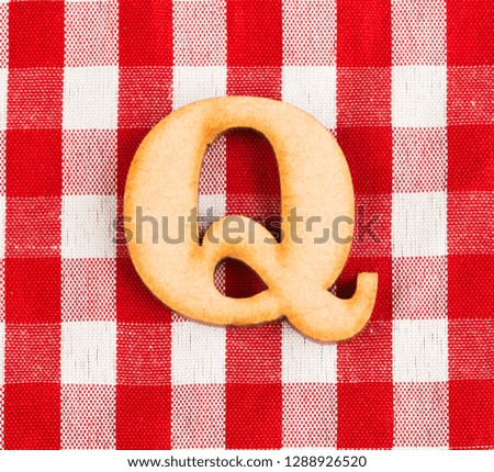 Letter Q of the alphabet - Red checkered fabric tablecloth.