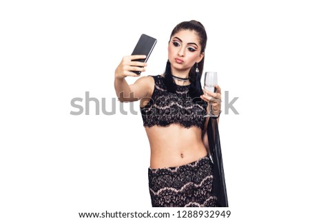 young gorgeous girl holds a glass of champagne and taking selfie. isolated on white