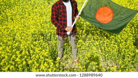Young man standing in a place holding the Bangladeshi national flag