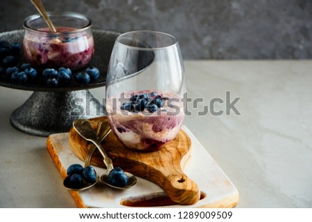 Fresh blueberry dessert in glass with berries, grey background. Summer refreshing desert - Image