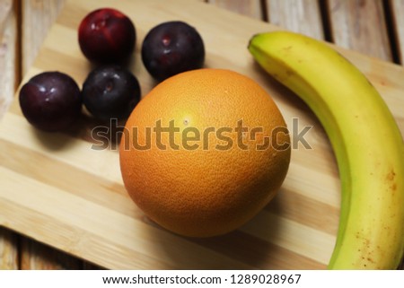 oranges, bananas, plums at the top of the board