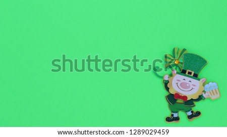 irish leprechaun holding beer mug isolated laying flat on a green background with writing space