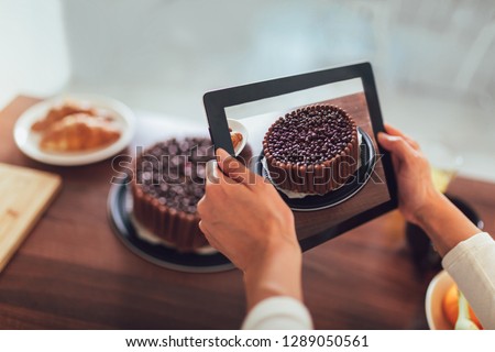 Blogger taking picture of cake to upload on website 