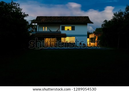 Night view of a house with lights on. Evening.