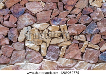 Fragment of a wall from a colour chipped stone background texture photo