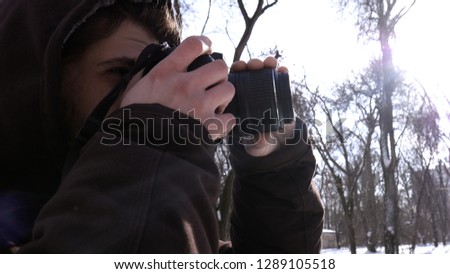 Young mellennial man take photos by his dslr camera. Winter landscape photographer