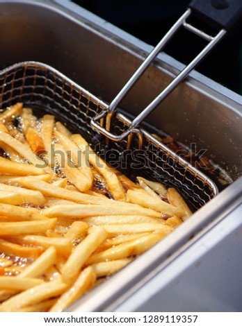  Closeup view of making french fries  deep frying in an equipment in fast or Indian fast food court                                 Royalty-Free Stock Photo #1289119357