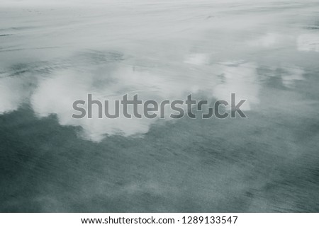 Clouds reflected in wet sand at Makorori Beach, near Gisborne, New Zealand 