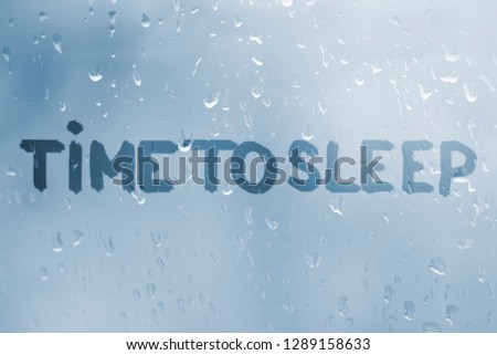 Autumn rain, the inscription on the sweaty glass - time to sleep, window with handwritten words 