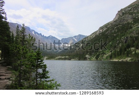          picture of a lake, trees, snow and mountains                