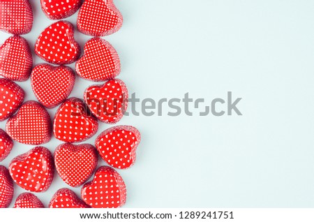 Bright red hearts on mint pastel paper background as decorative border with copy space. Valentine's day youth design concept art. 