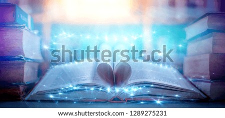 image of open antique book over wooden table 