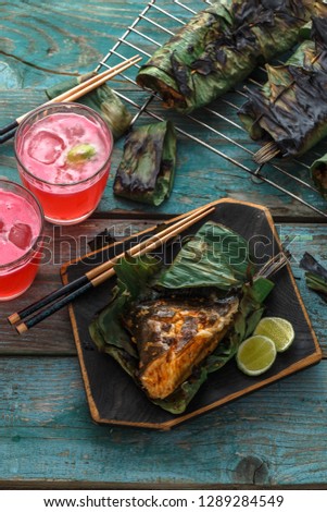 Grilled stingray wing or sambal stingray in leaf with lime and spicy dressing, malaysian cuisine
