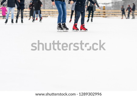 people ride on an open ice rink in winter