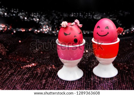 Happy easter red eggs with painted drawn cartoon faces on black shiny background. Boy gives girl rose flower. Simplicity concept Valentine's Day, Easter.