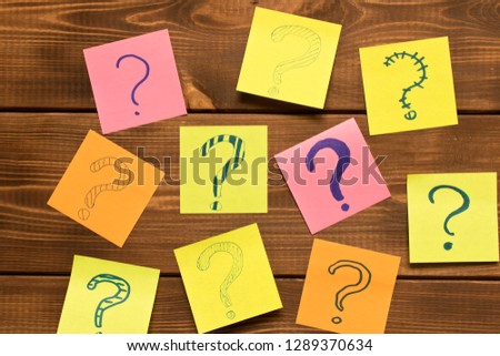 Different colored stickers with questions on wooden background. Concept of idea development.