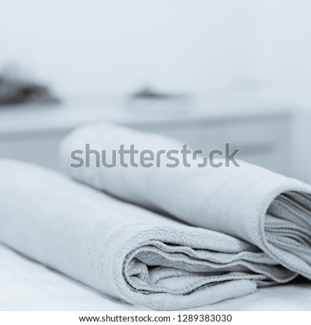 Set of two colorful cotton towels lying on massage table. photo converted in black and white with a blue tint
