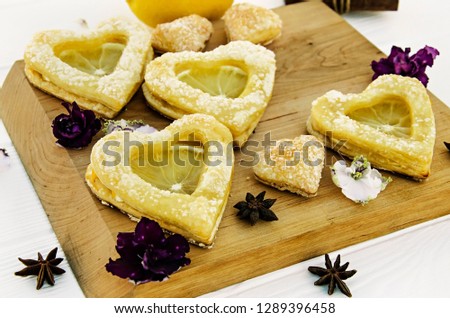 Puff pastry with lemon in the form of a heart on a light wooden board. For tea on Valentine's Day.