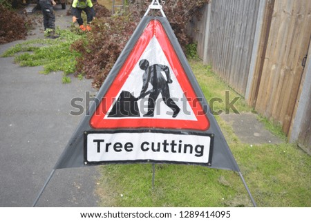 Triangular red and grey sign warning for tree cutting 