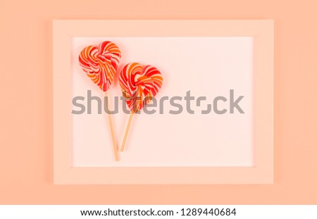 Lollipop in a white frame. Coral background.