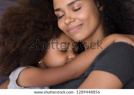 Loving single black mother hugs cute daughter feel tenderness connection, happy african mum caressing embracing little girl, mommy kid cuddle, warm relationships, child custody, foster care concept Royalty-Free Stock Photo #1289448856