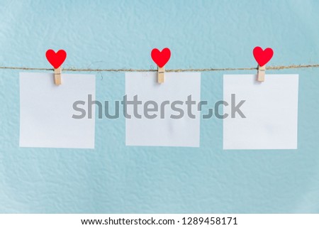 Blank cards on pins with red hearts. Mockup for text and blue background for Valentines Day greetings