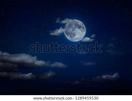 Moon and clouds in the night. Moonlight background. Dark blue backdrop.
