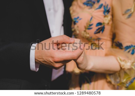Bridal couple holding hands. Close-up picture without faces.
