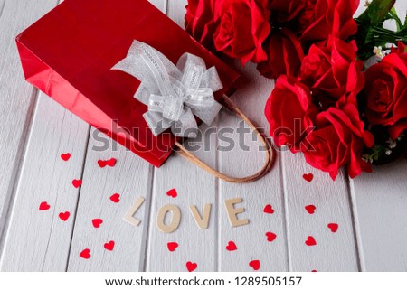 Valentines background with red rose, Heart shape, Gift bag, Wooden letters word "LOVE" on white wooden table