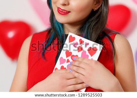 a beautiful young woman takes a card with hearts with a Declaration of love. Valentine's day 14 February
