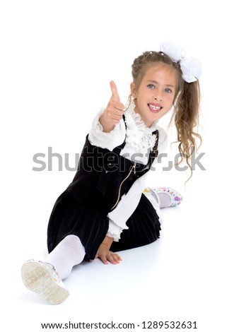 Little girl schoolgirl, performs gymnastic twine in the studio on a white background. Concept of fitness and sport and healthy lifestyle.