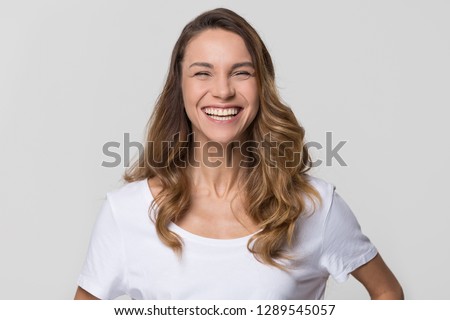 Cheerful happy millennial woman laughing looking at camera isolated on white studio blank background, smiling funny young girl having fun, portrait, healthy teeth dental care, orthodontic service Royalty-Free Stock Photo #1289545057