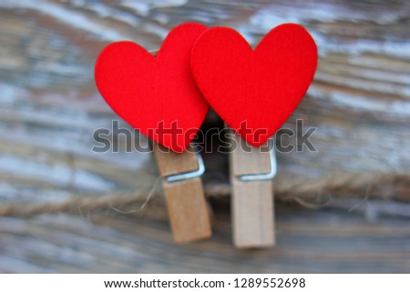 Red hearts on clothespins hold the heart out of the slate with the inscription I love you, hang on a rope on a wooden background. Happy Valentine's Day and 8 March Concept. Place for text, copy space.