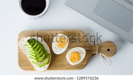 Overhead view of laptop, fresh toast with avocado, mug of coffee. Woman business, freelancer concept. Healthy breakfast food. Top view and flat lay