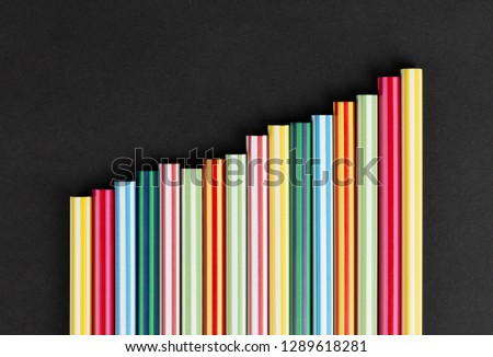 colored pencils lined up in row on black background top view. Art set of pencils for schoolboy with free space. view from above