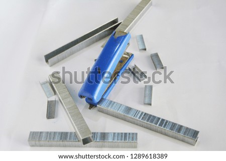 Blue stapler and staples on a white background