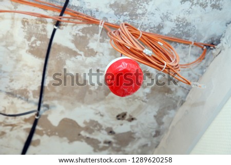 Closeup installation and repair of electric cable, smoke detector, fire alarm system before installing a stretch or suspended ceiling. Concept of testing fire extinguishing systems, protection